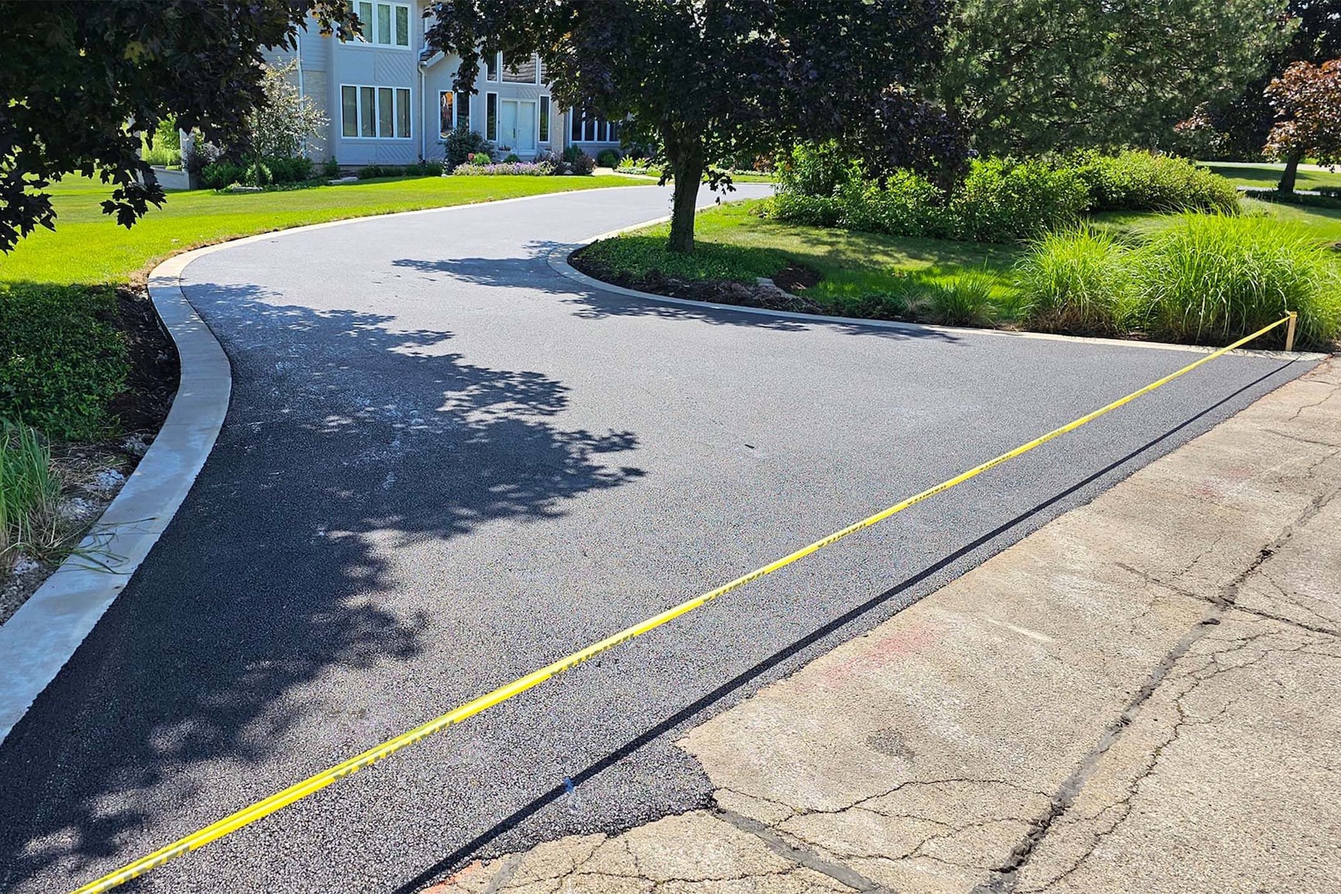 Residential asphalt driveway under construction.